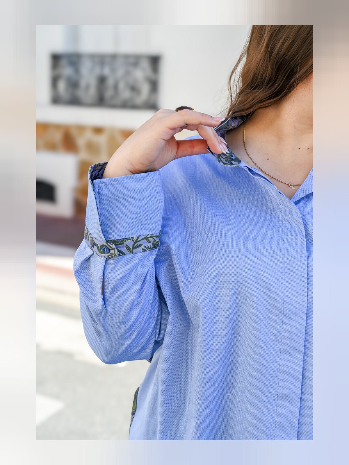 Gros plan sur le col et le poignet retroussé imprimés de la chemise bleu ciel en coton