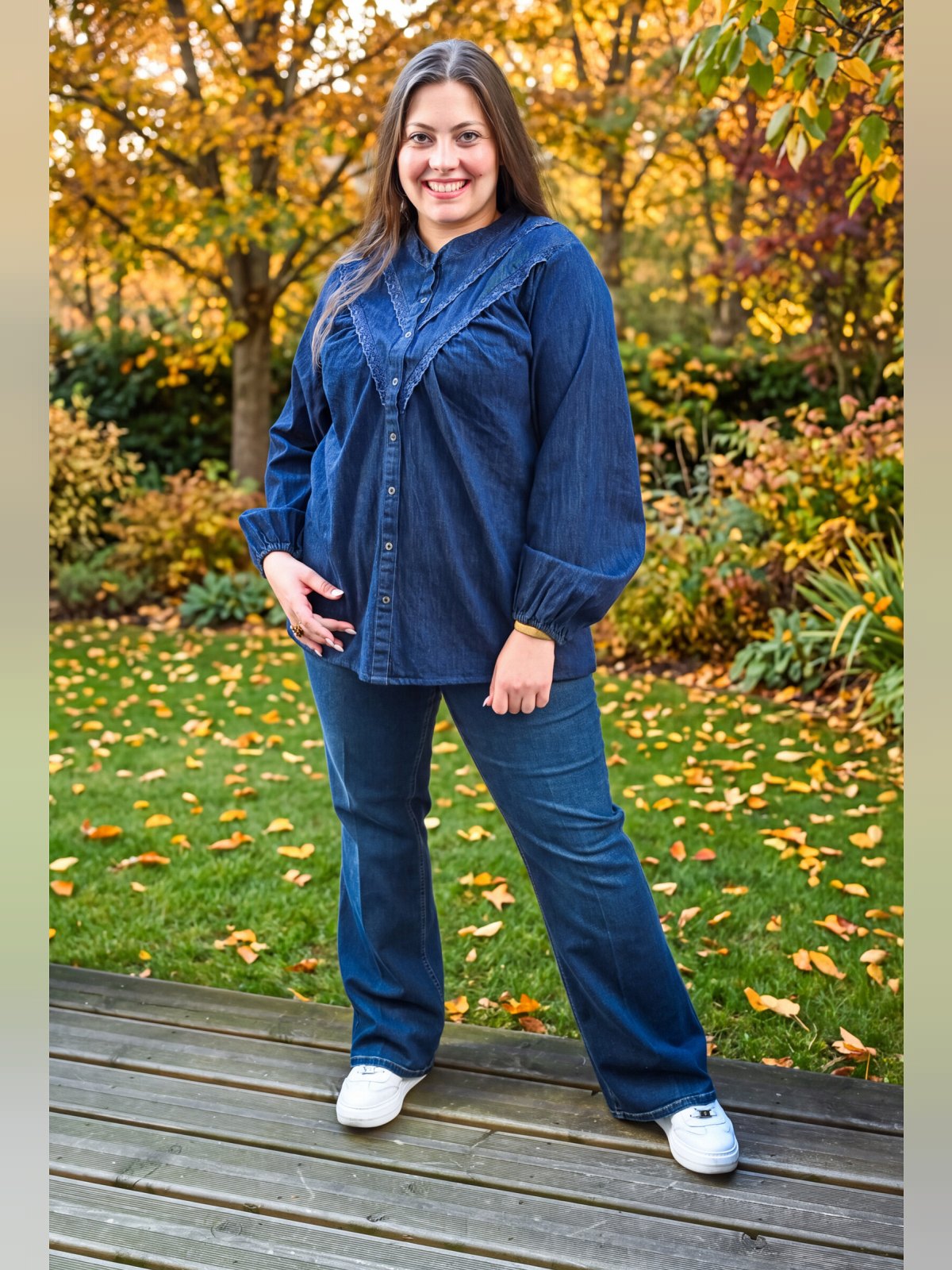 Chemise en jean bleu brut portée de face, col montant, plastron en V dentelle et manches bouffantes