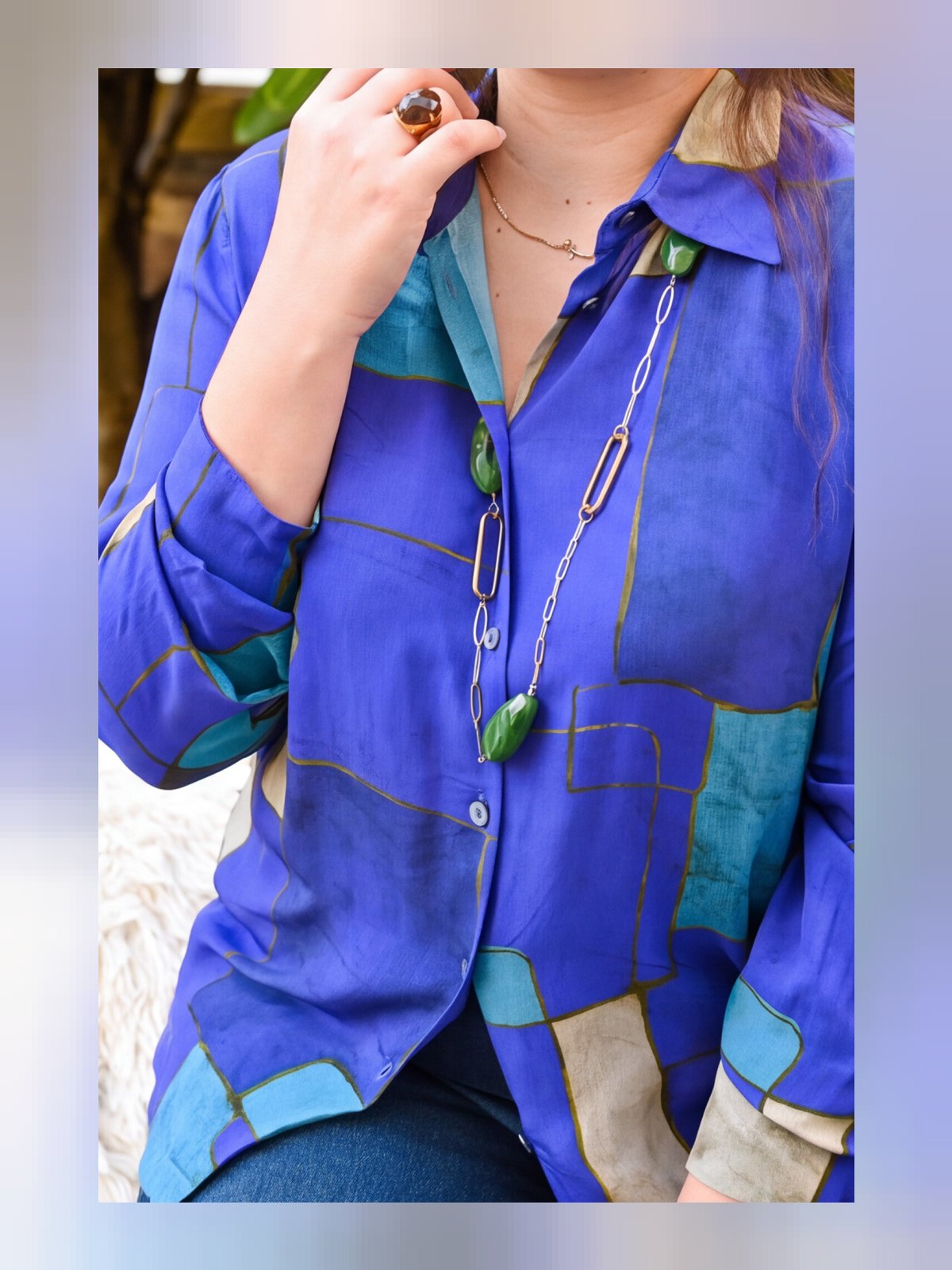 Gros plan sur le col chemise et l'imprimé géométrique bleu et turquoise d'une chemise fluide