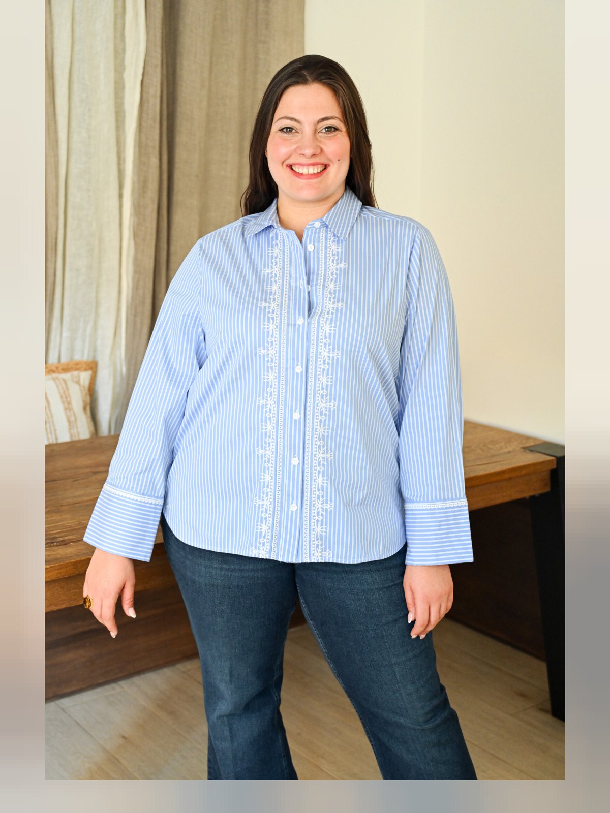 Chemise rayée bleu ciel et blanc, broderies le long du boutonnage, portée de face avec un jean
