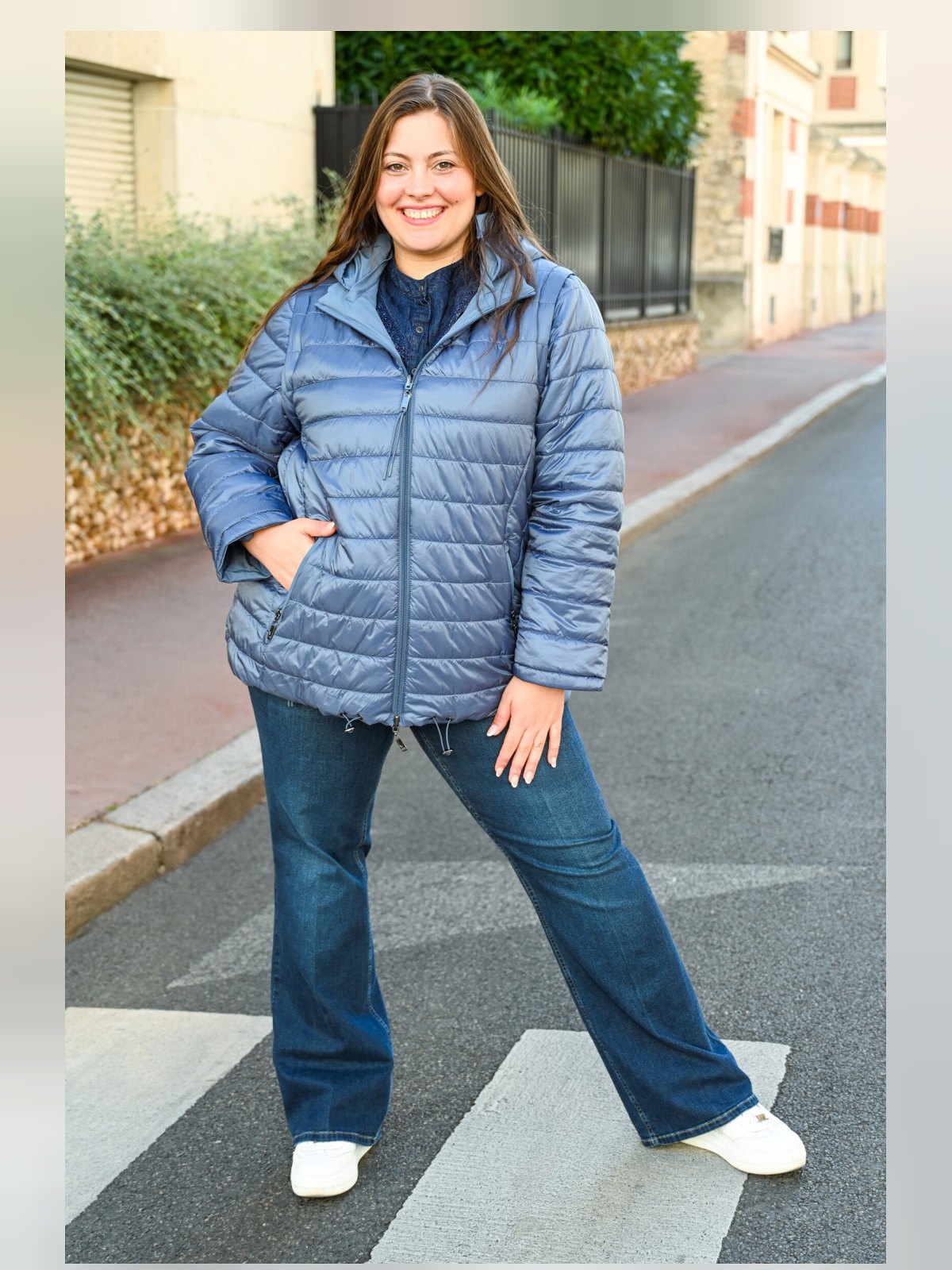 Doudoune matelassée réversible bleue portée côté matelassé, zippée, avec jean flare et baskets blanches