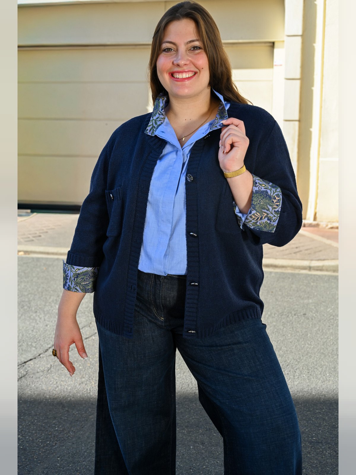 Gilet bleu nuit avec poches poitrine et boutons, porté ouvert sur une chemise bleu ciel et un jean