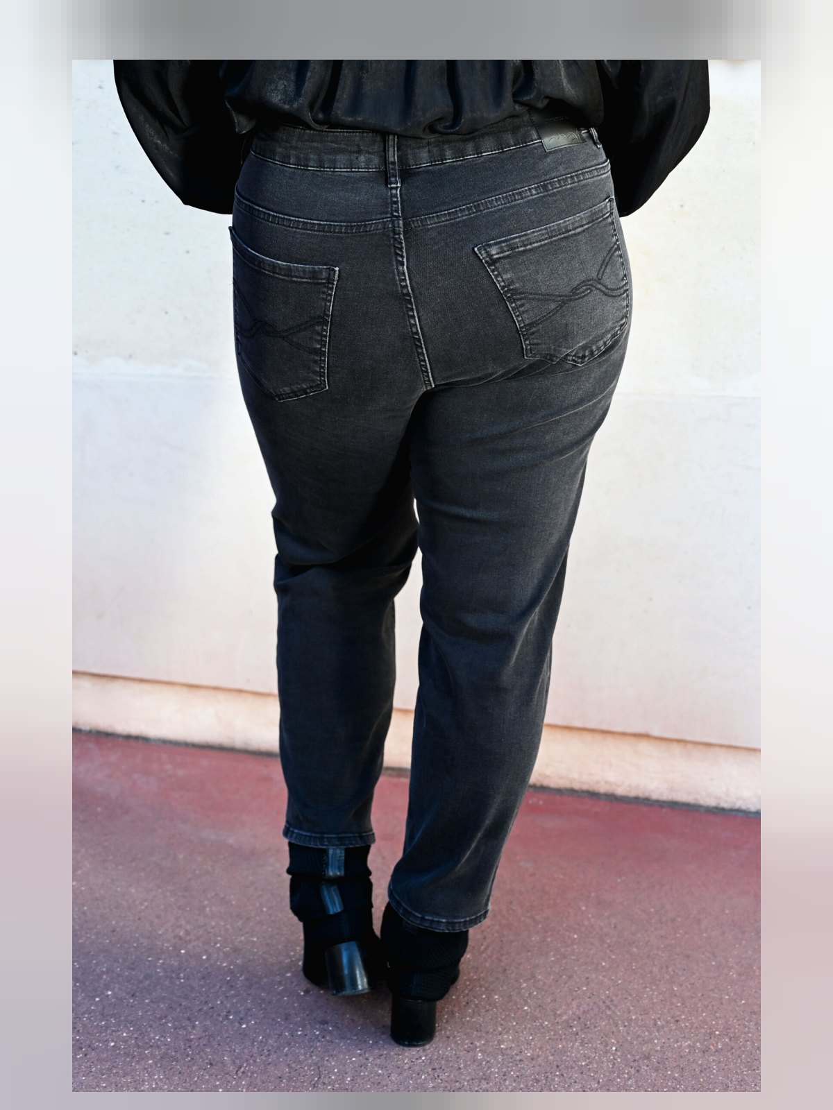 Dos du jean noir délavé avec poches arrière surpiquées et coupe droite longueur cheville