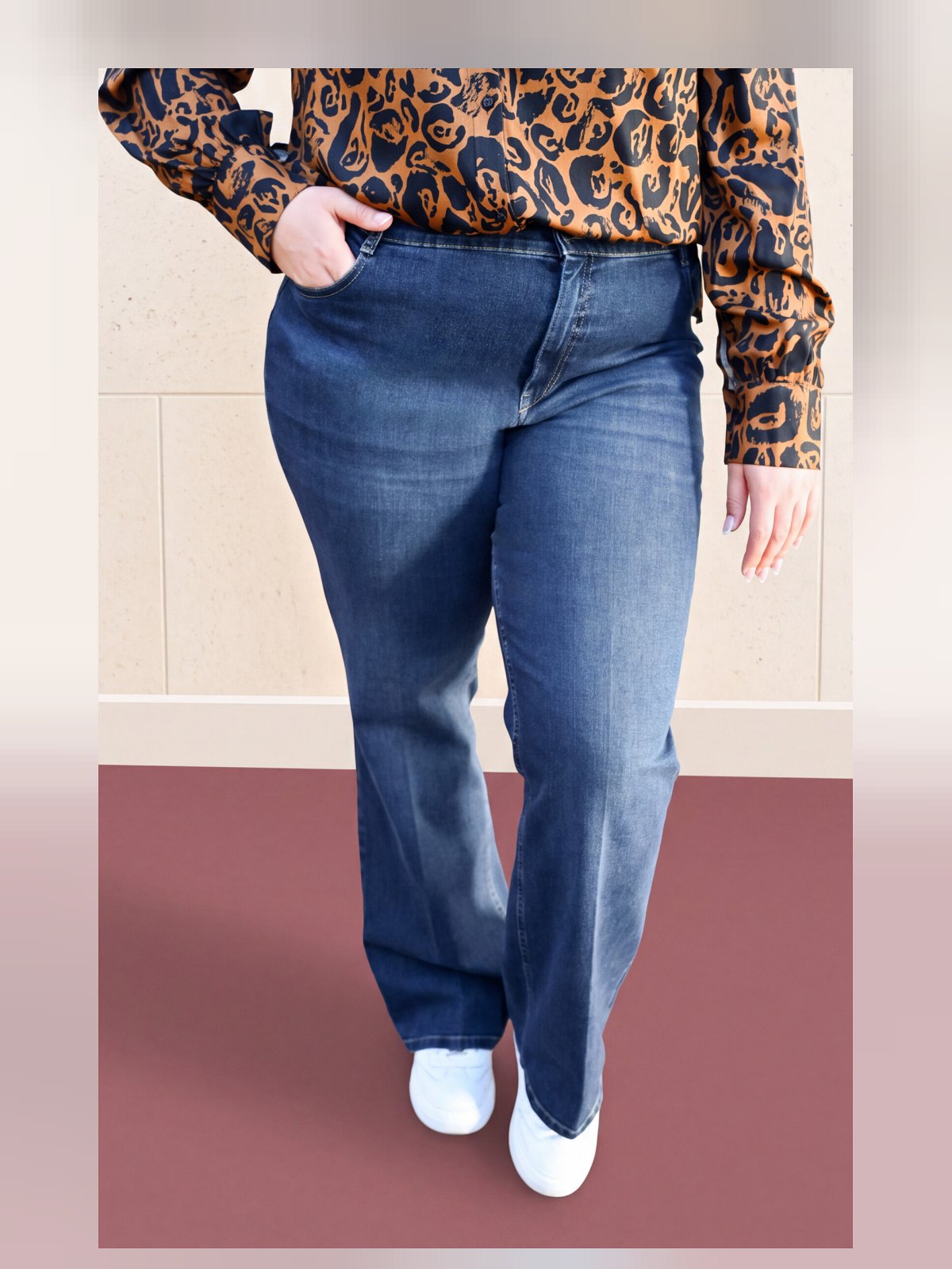 Jean flare bleu taille haute porté, vue rapprochée de face montrant poches et pli marqué