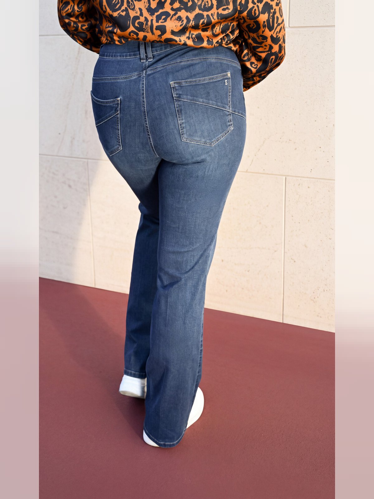 Jean flare bleu porté vu de dos avec poches plaquées surpiquées et coupe évasée