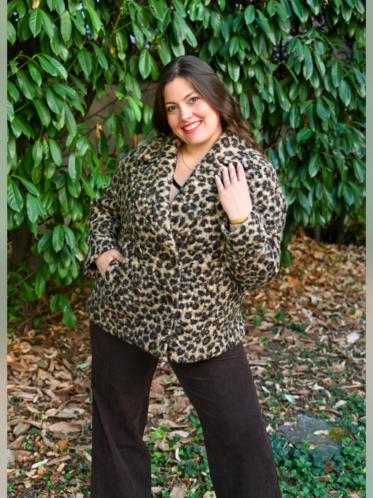 Manteau caban court imprimé panthère porté de face avec un pantalon large chocolat, double boutonnage
