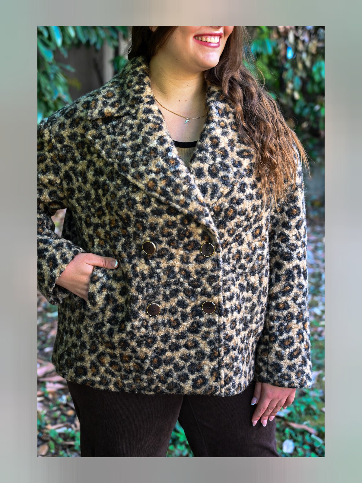Gros plan sur le col à revers et le double boutonnage du manteau caban imprimé panthère