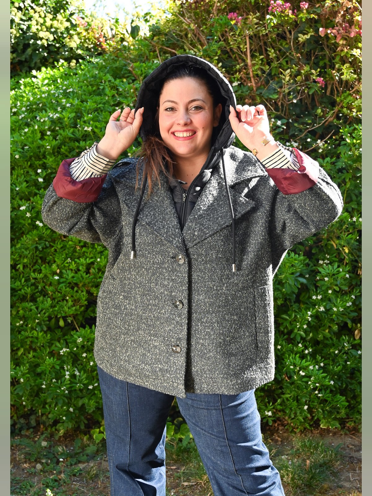 Manteau caban en laine chiné gris porté avec la capuche amovible relevée sur la tête